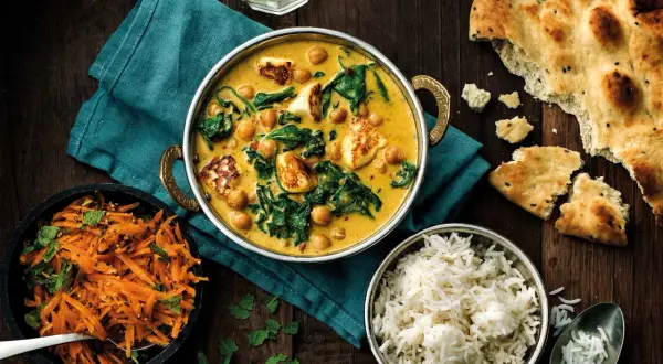 En krämig curry med kikärtor, spenat och paneer, serverad med ris, morotssallad och naanbröd. Perfekt för ett garam masala recept.