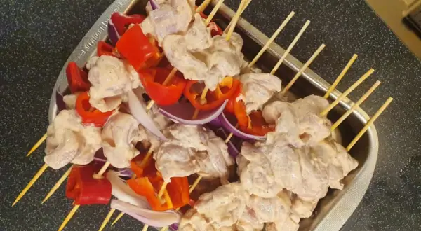 Shish tawook-spett på spett med kyckling, röd paprika och lök, redo att grillas.