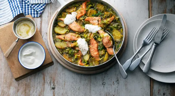 En härlig ugnsbakad lax med potatis och purjolök, perfekt för ett enkelt lax recept. Serveras med en klick gräddfil.