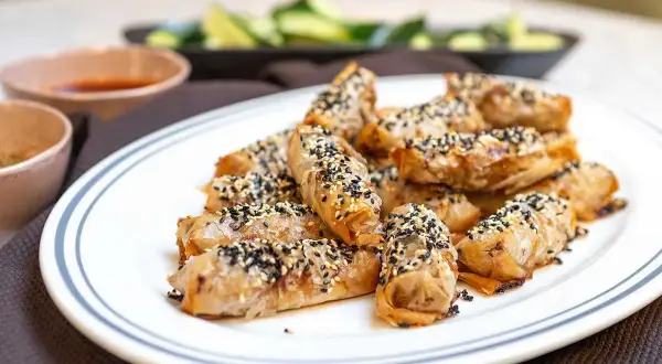 Krispiga vårrullar med sesamfrön, redo att serveras med dippsås. Ett perfekt vårrullar recept för alla tillfällen.