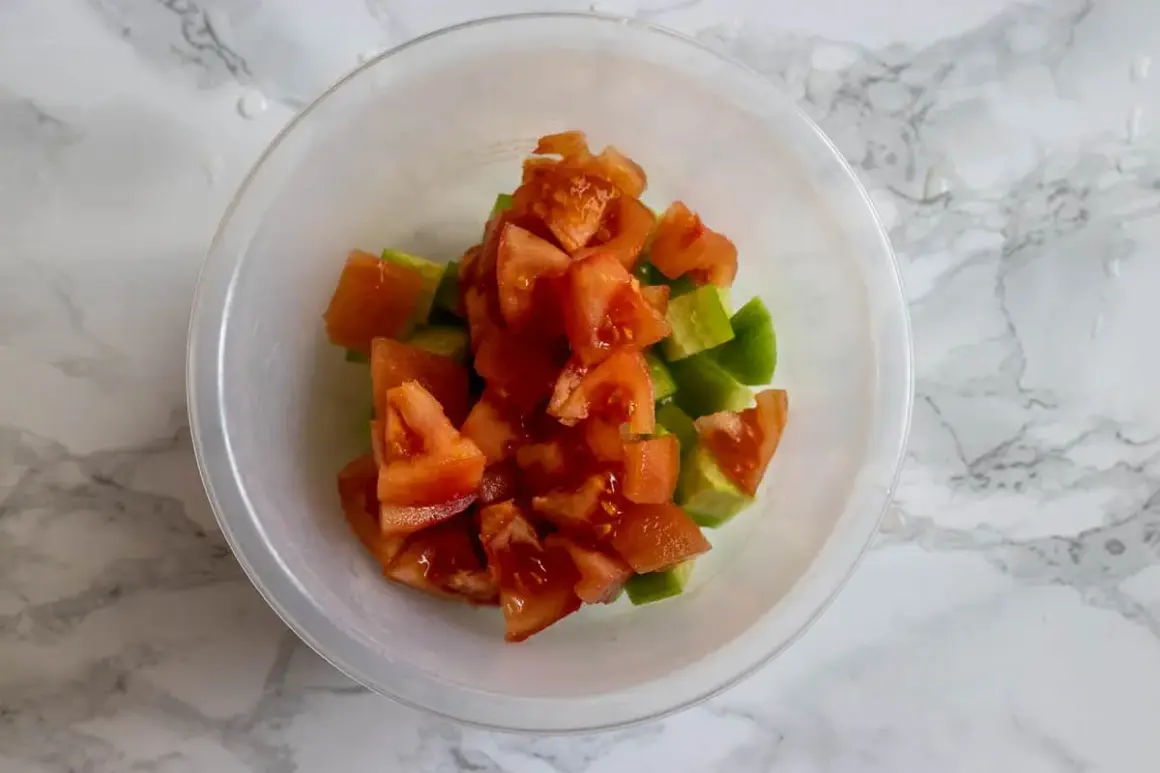 Tärnad tomat och gurka i en skål, redo att bli en fräsch sallad shirazi.