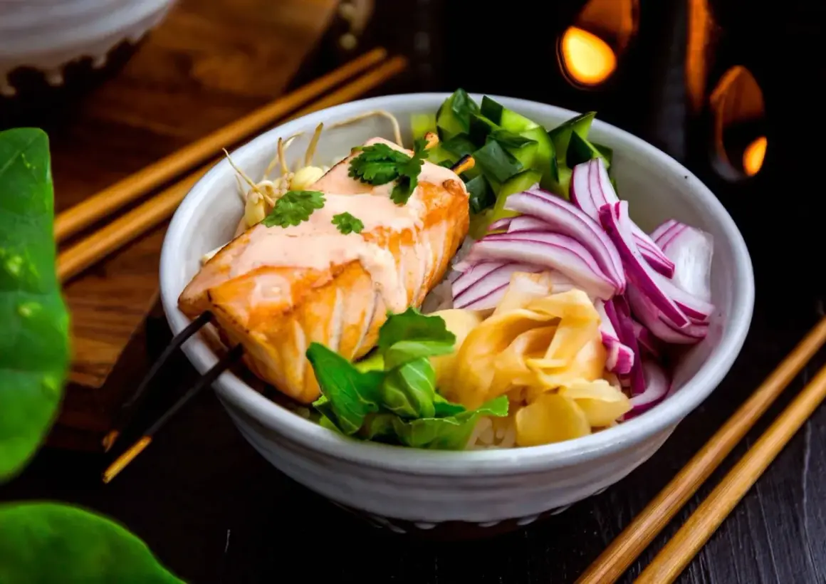 En läcker lax poke-bowl med ris, gurka, rödlök och ingefära. En krämig sås toppar den saftiga laxfilén.