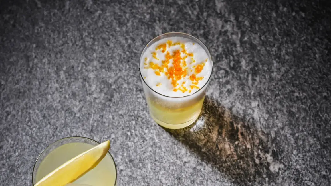 Två uppfriskande drinkar, en med citronskiva, den andra toppad med skum och yuzu-zest. Perfekt för ett yuzu recept.