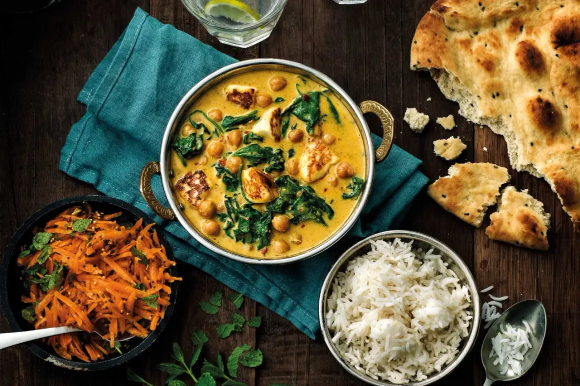 En krämig curry med kikärtor, spenat och paneer, serverad med ris, morotssallad och naanbröd. Perfekt för ett garam masala recept.