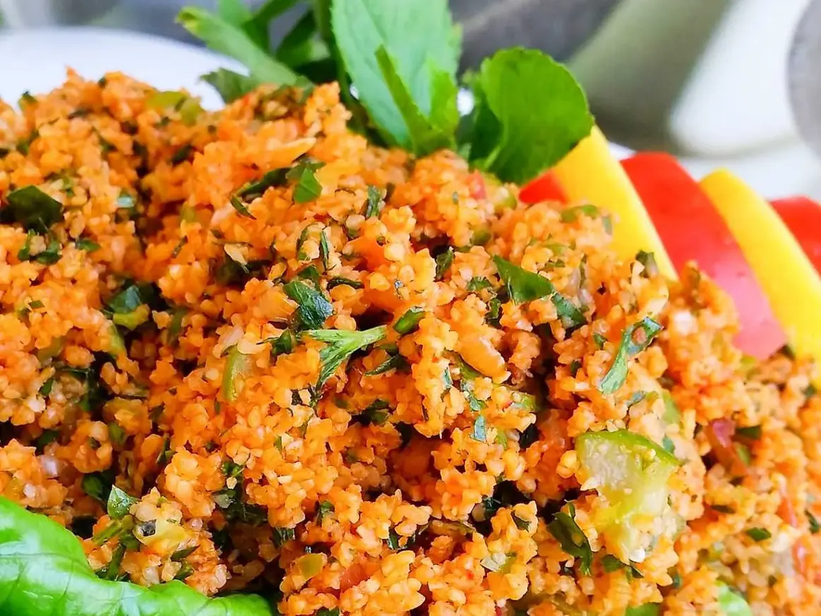 En närbild på en läcker kisir-sallad, full av bulgur, örter och grönsaker. Perfekt för ett lätt och smakrikt mellanmål.