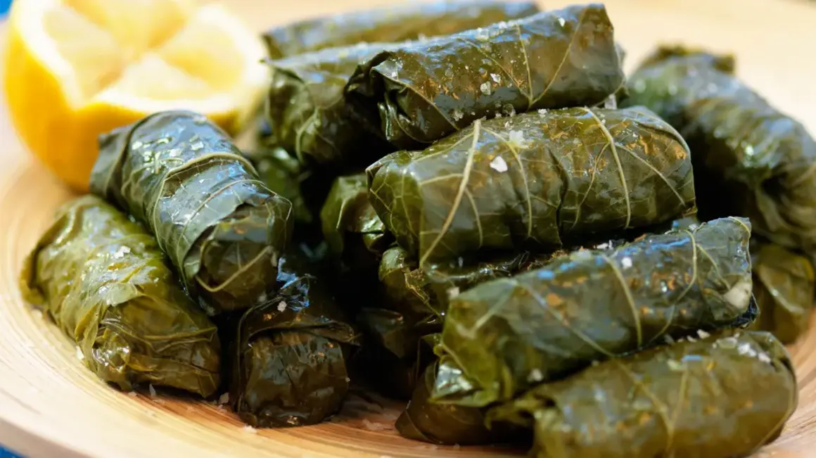En hög med sarma, vindruveblad fyllda med ris och kryddor, serveras med en citronklyfta. Ett utsökt sarma recept!