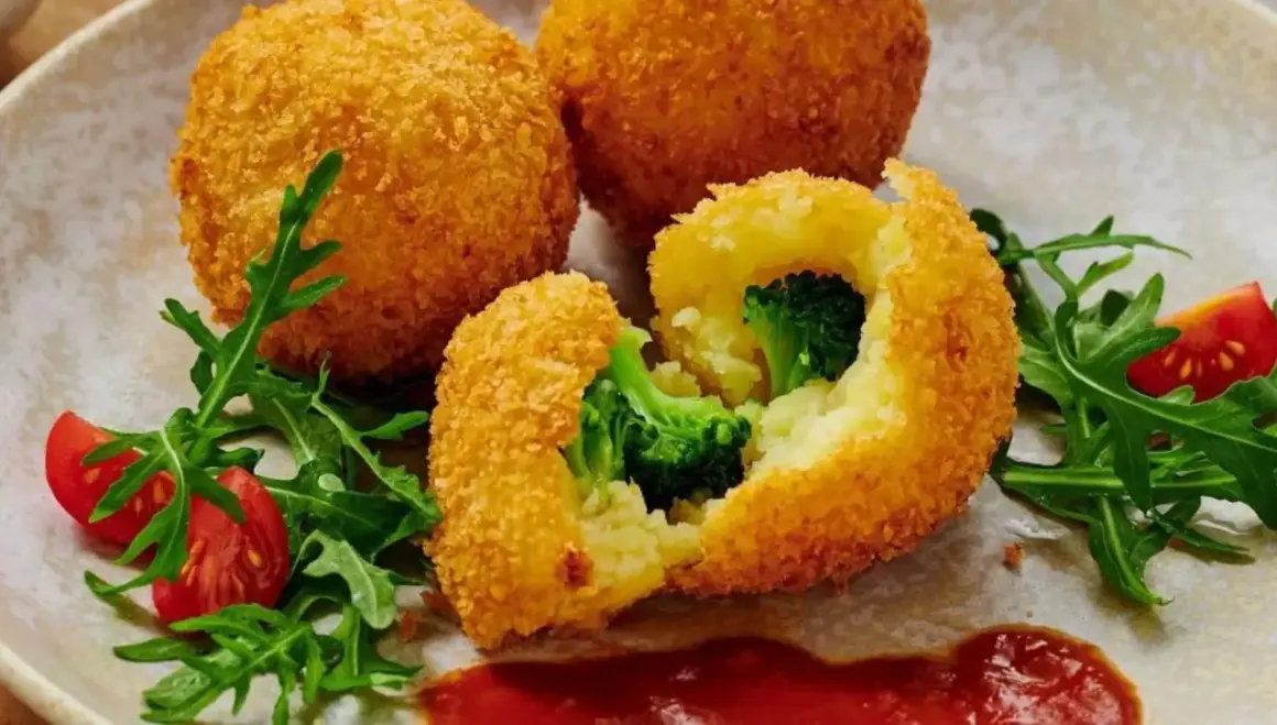 Krispiga bollar med potatis och broccoli, panerade i panko. Serveras med tomater och ruccola.
