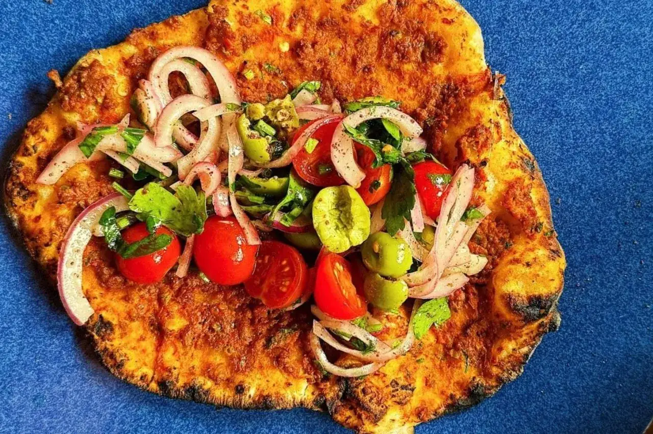 Lahmacun med färsk topping av tomat, lök och oliver. Ett enkelt lahmacun recept för en god måltid.