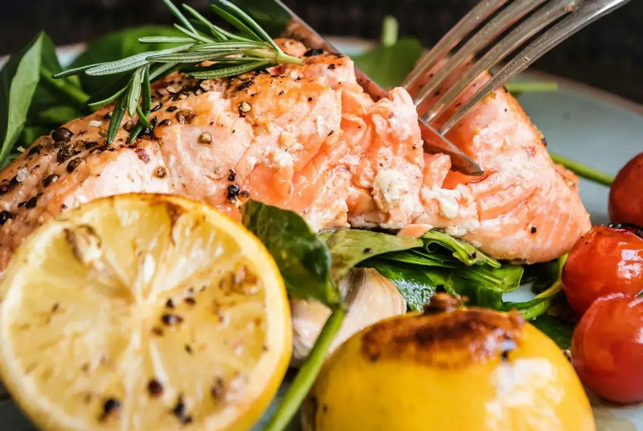 En saftig lax i ugn, perfekt tillagad med citron och rosmarin. Serveras med färska grönsaker och körsbärstomater.