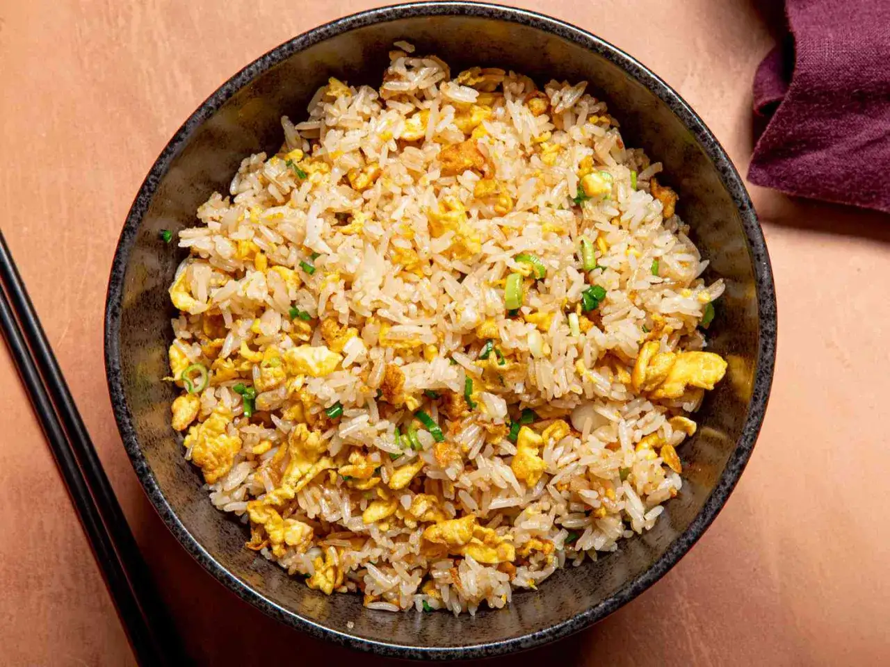 En sk&aring;l med fluffigt ris blandat med &auml;ggr&ouml;ra och gr&ouml;n l&ouml;k. Enkel och god egg rice.