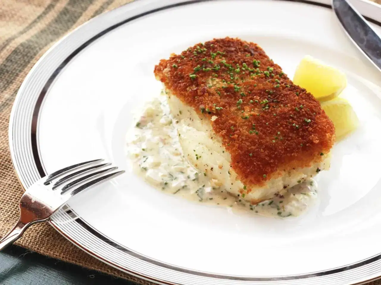 Panerad havsabborre med krämig sås och citronklyftor. Ett utsökt havsabborre recept för en fin middag.