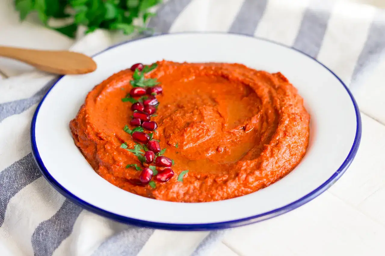 En krämig muhammara, perfekt för ditt nästa recept. Garnerad med granatäppelkärnor och persilja.