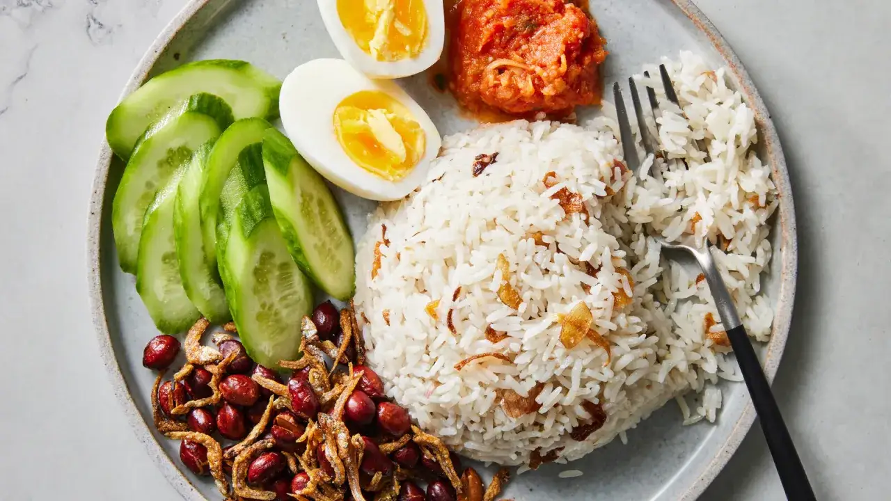 Nasi lemak med ris, ägg, gurka, jordnötter, ansjovis och sambal. En härlig måltid!