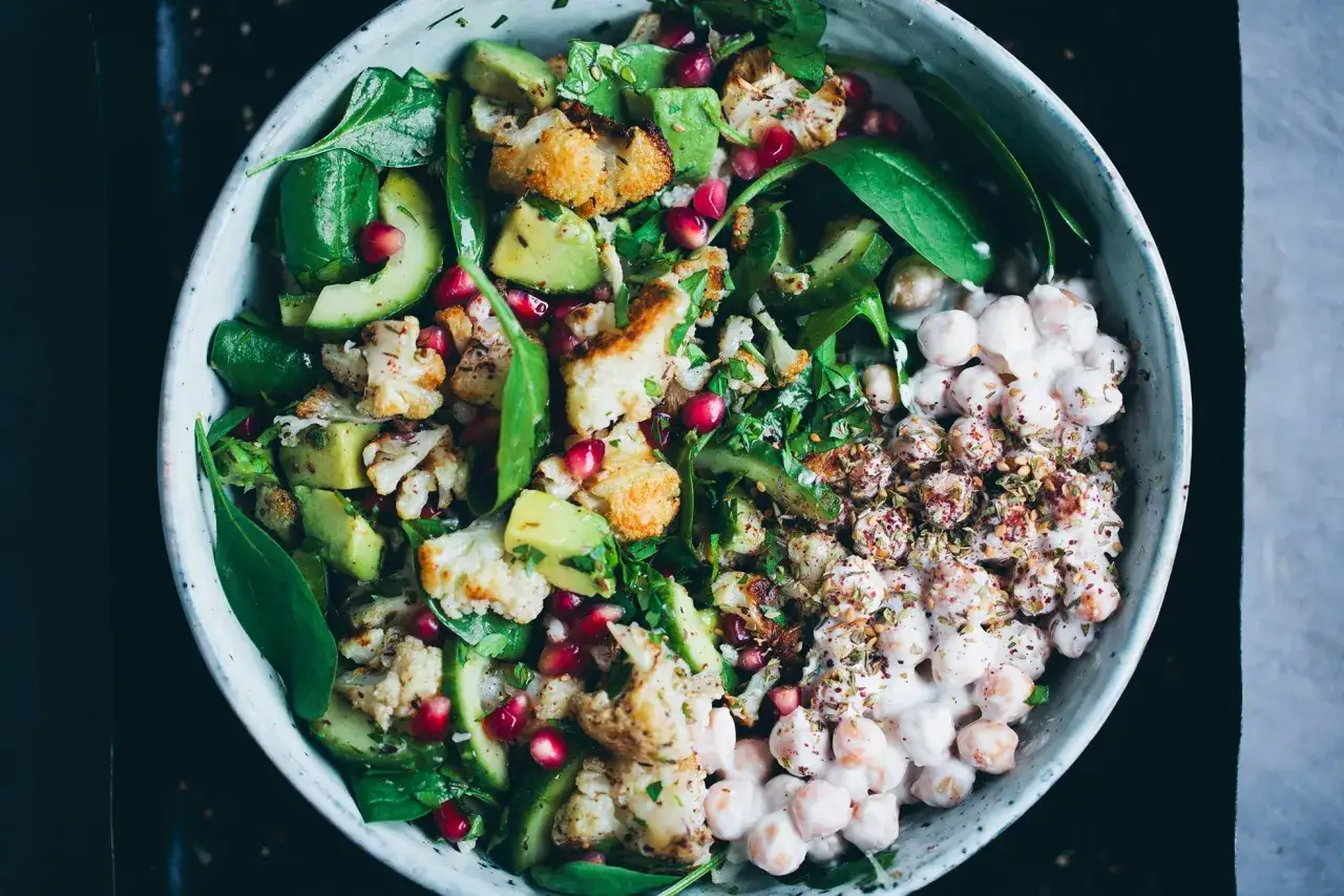 En härlig blomkål sallad med avokado, granatäpple och krämiga kikärtor. En fräsch och mättande rätt.