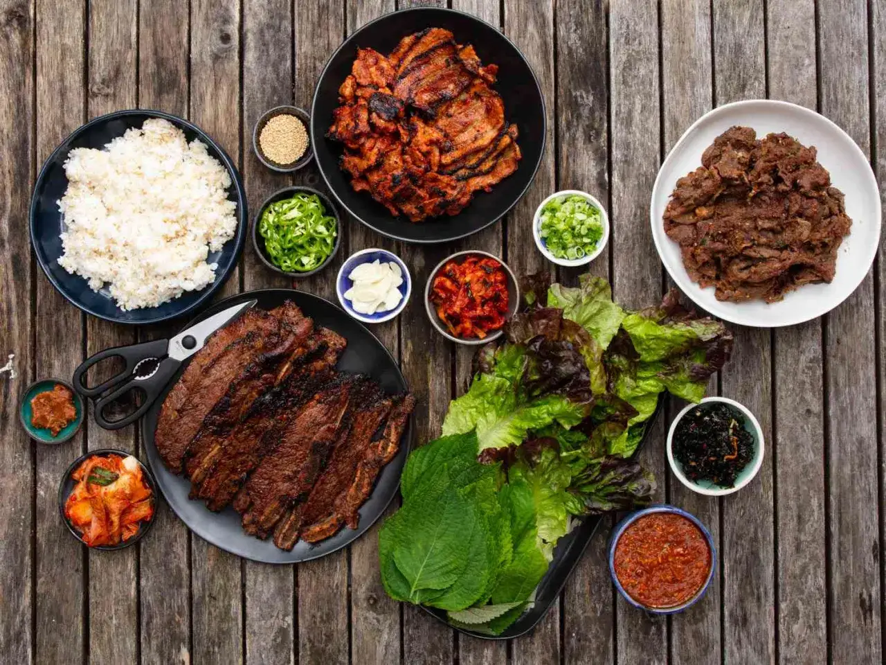 Grill-inspiration: Koreansk BBQ med grillade revbensspjäll, bulgogi, ris, sallad och kimchi. Perfekt för en festlig middag!