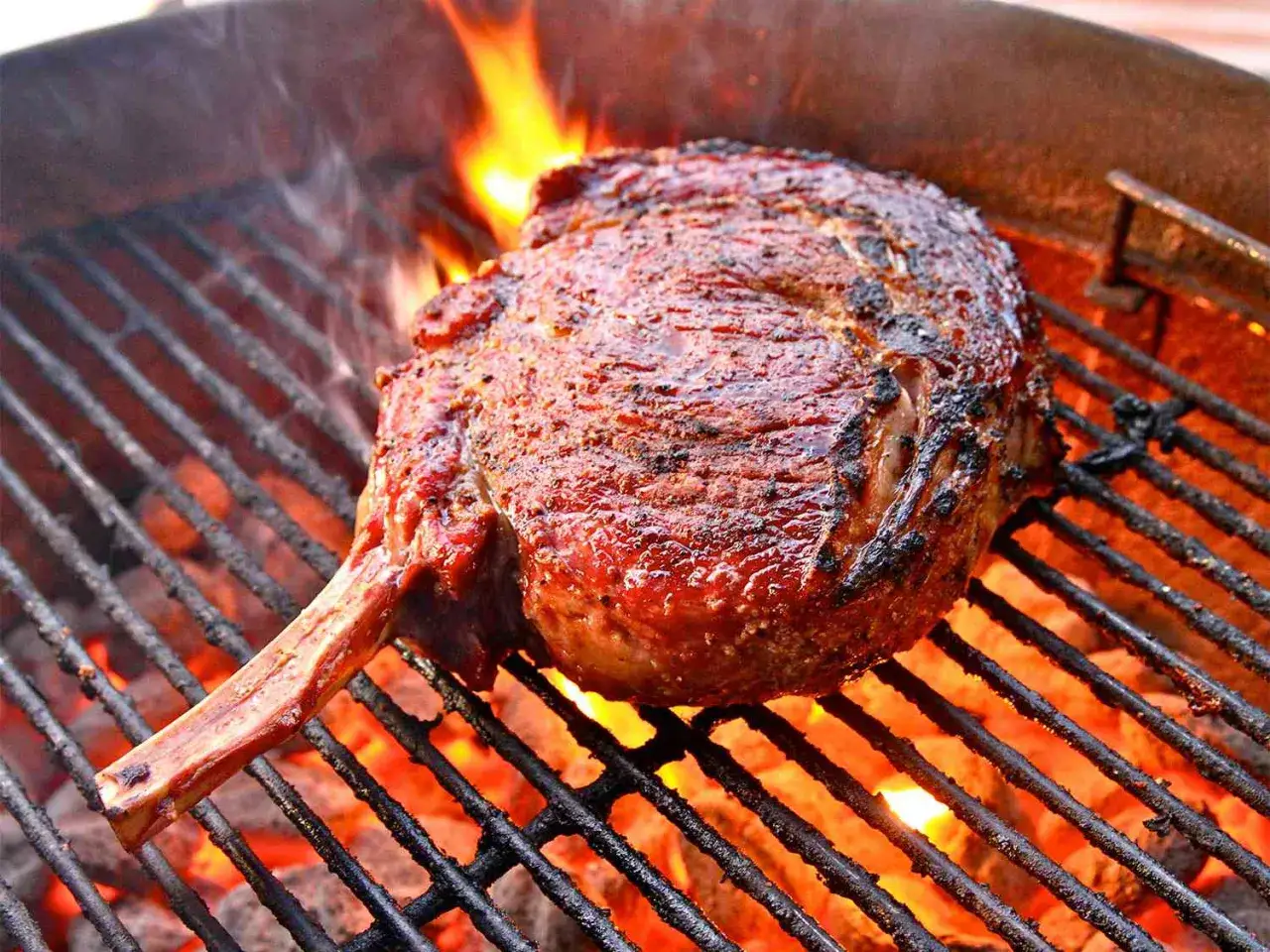 En saftig köttbit med ben grillas över glödande kol. Perfekt för ett somrigt grill recept.