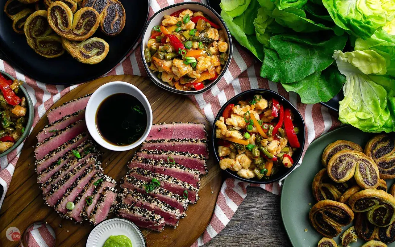 En härlig uppdukning med asiatisk tapas: sesampanerad tonfisk, kyckling med grönsaker och söta bakverk.