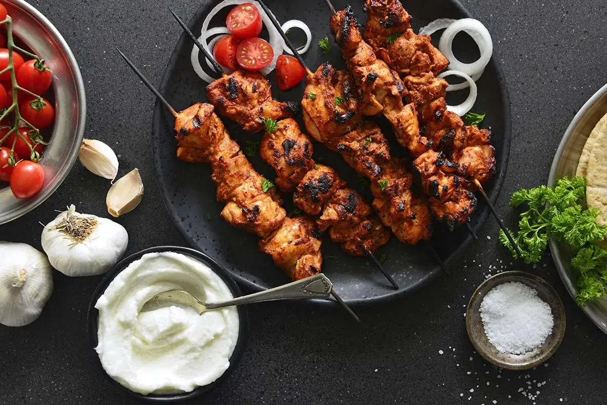 Grillade shish tawook-spett med tomater, l&ouml;k och vitl&ouml;ksyoghurt.