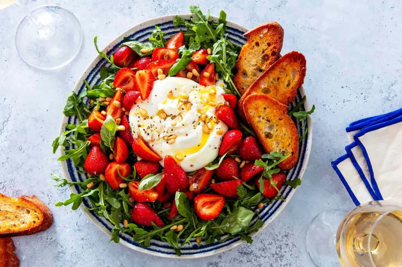 En kr&auml;mig burrata med jordgubbar, ruccola och rostade krutonger. Ett perfekt burrata recept f&ouml;r en l&auml;tt lunch eller f&ouml;rr&auml;tt.