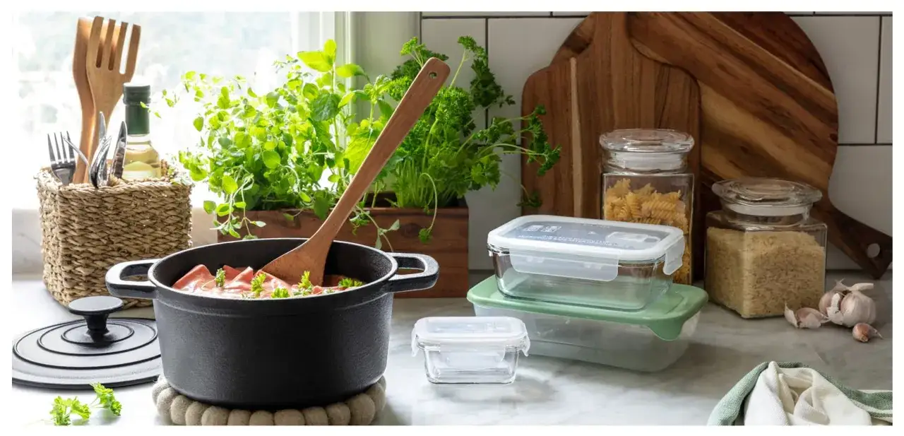 Kökets förberedelser: gryta med mat, färska örter, glasburkar med pasta och ris, samt matlådor för att frysa in mat.