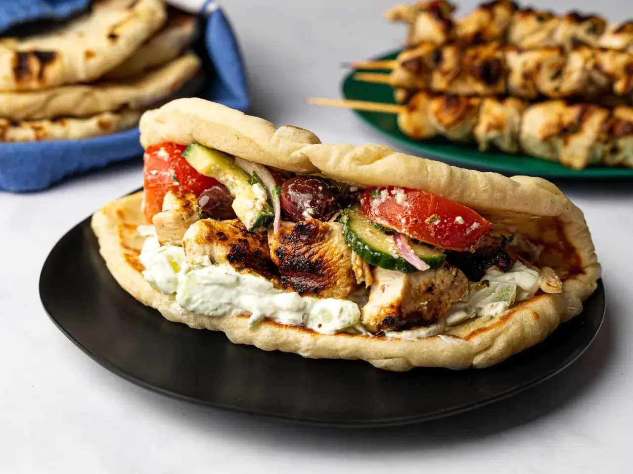 En l&auml;cker gyros med grekiska kycklingspett, tzatziki, tomat, gurka och oliver i ett mjukt pitabr&ouml;d.
