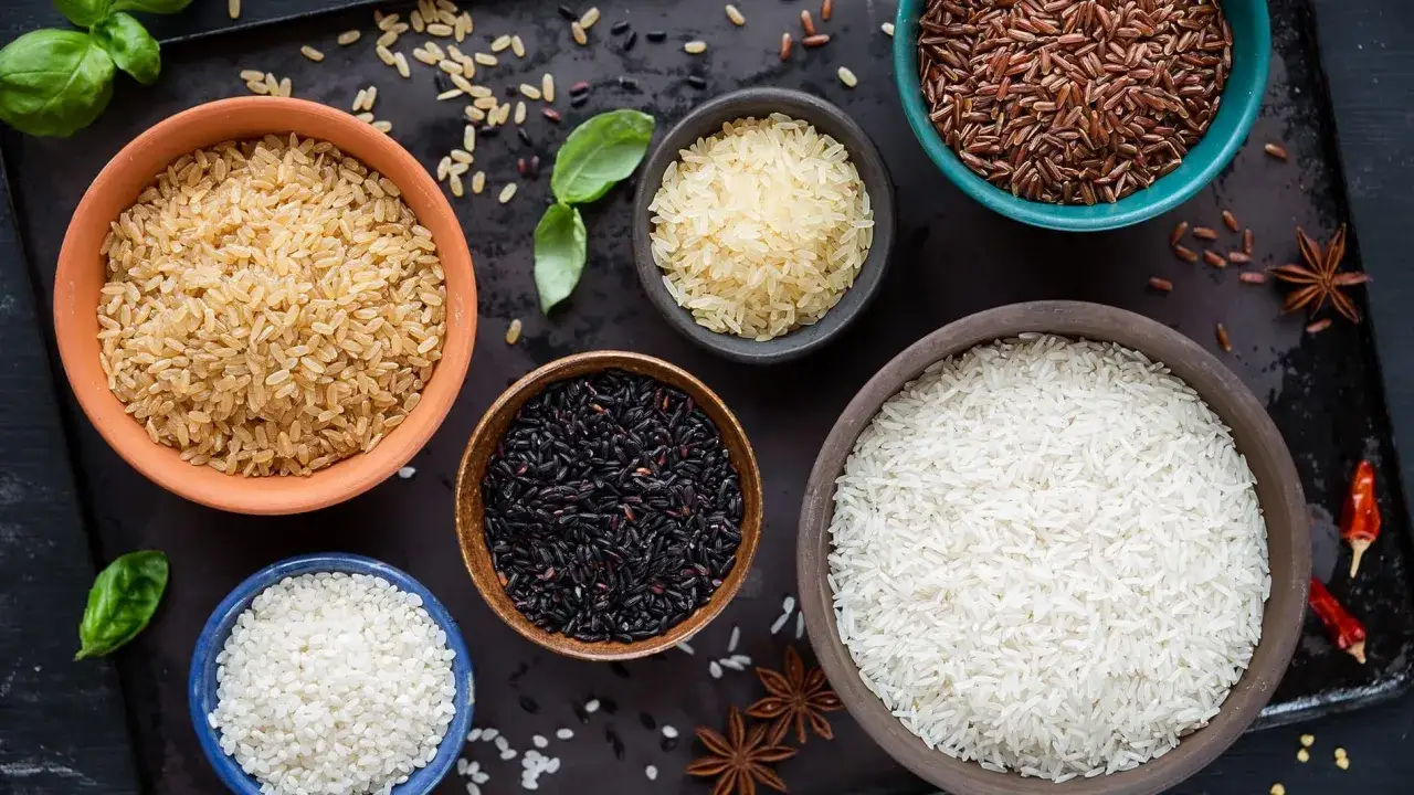 Fem sk&aring;lar med olika sorters ris: vitt, brunt, svart, r&ouml;tt och gult. Kanske basmati eller jasminris i n&aring;gon av dem.