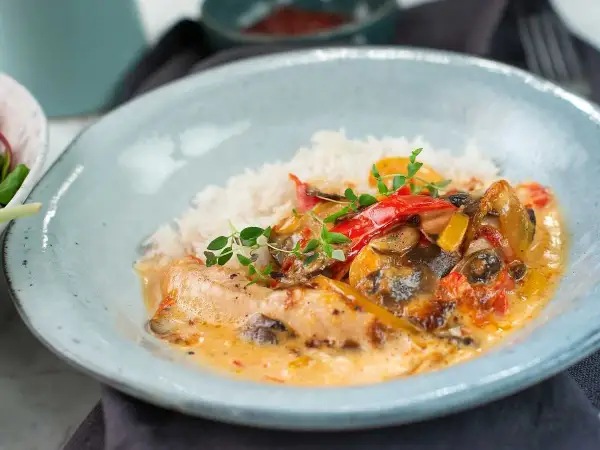 En krämig kycklinggryta med ris, paprika och champinjoner. En härlig rätt som passar perfekt för en mysig middag.